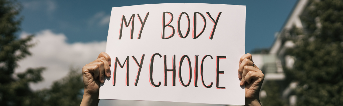 handen die een bord vasthouden met de tekst 'my body my choice'