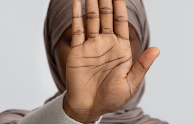 moslima die haar hand opsteekt om stop te zeggen